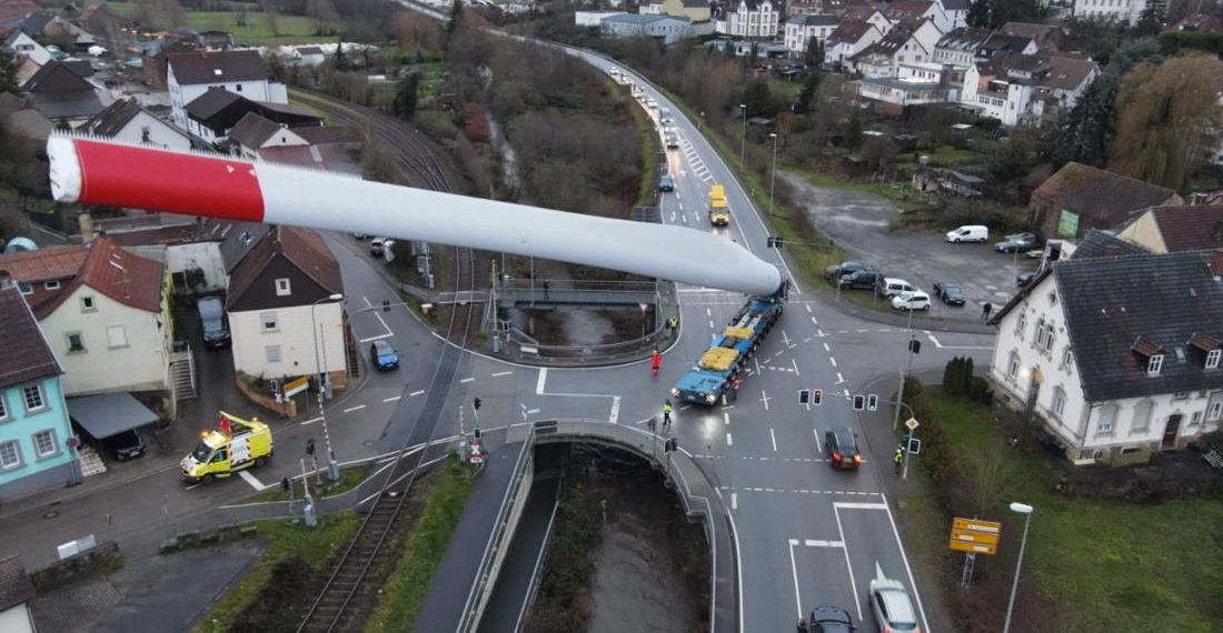 Aerial Shots Of A Tractor Trailer Hauling A 220-Foot Wind Turbine Blade At An Angle