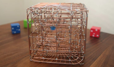A Marble Maze Inside A Bent Copper Wire Cube