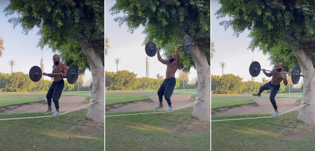 Man Works Out With Barbell While Slacklining