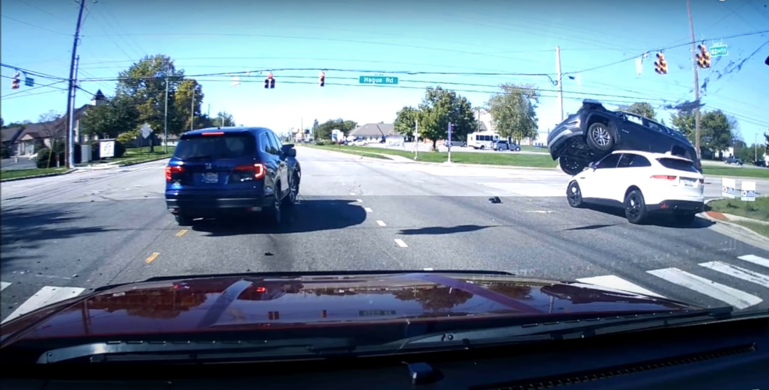 Car Runs Red Light, Crashes, Lands On Top Of Another Moving Car