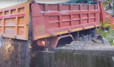 Dump Truck Collapses Sidewalk, Dumps Load In Canal