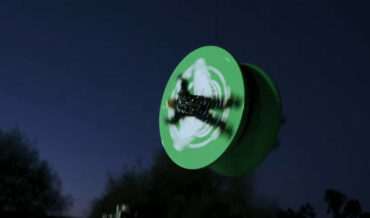 Two Dudes Spin On Sides Of Giant Yo-Yo Suspended From Crane