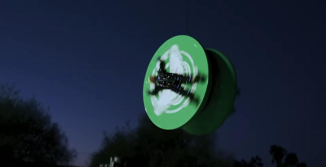 Two Dudes Spin On Sides Of Giant Yo-Yo Suspended From Crane
