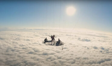 Jumping On A Trampoline Suspended Below A Hot Air Balloon Above The Clouds